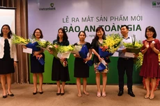 Bà Đoàn Hồng Nhung - Trưởng phòng Quản lý Bán sản phẩm bán lẻ, Thành viên HĐTV Công ty VCLI (thứ 2 từ phải sang) và bà Young Lai Yin - Tổng giám đốc VCLI (ngoài cùng bên trái) tặng hoa chúc mừng các khách hàng tham gia sản phẩm Bảo an Toàn gia