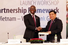 Giám đốc quốc gia WB tại Việt Nam Ousmane Dione trao sách công bố Khung đối tác quốc gia của Việt Nam cho Bộ trưởng Bộ Kế hoạch và Đầu tư Nguyễn Chí Dũng. Ảnh: Trần Việt