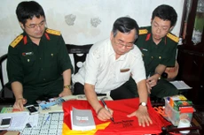 Nhà báo Nguyễn Khắc Xuể ký tặng lên lá Quốc kỳ gửi bộ đội Trường Sa