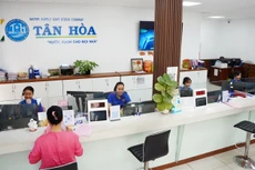 Nhân viên Công ty CP Cấp nước Tân Hòa hỗ trợ khách hàng đến giao dịch