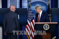 Mật vụ Mỹ hộ tống Tổng thống Donald Trump (phải) rời khỏi buổi họp báo tại Nhà Trắng khi xảy ra vụ nổ súng, ngày 10/8/2020. Ảnh: AFP/TTXVN