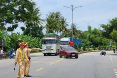 Lực lượng cảnh sát giao thông Công an tỉnh Quảng Ngãi thực hiện chỉ dẫn và phân luồng xe đi theo hướng mới thay thế hướng qua cầu Trà Khúc 2