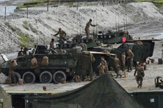 Lính Mỹ bên cạnh các xe thiết giáp hạng nhẹ chuẩn bị tập trận bắn đạn thật với Philippines hôm 10/10. Ảnh: AFP.