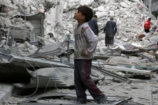 Một cậu bé đứng xem các căn nhà bị hư hại nặng nề sau đợt không kích nhằm vào phe nổi dậy tại Aleppo. Ảnh: Reuters.