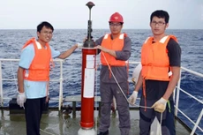 Các nhân viên kỹ thuật Trung Quốc bên cạnh một thiết bị cảm ứng nổi do nước này tự chế tạo. Ảnh: SCMP