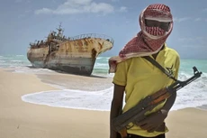 Cướp biển Somalia đứng trước một con tàu mà họ cướp năm 2012. Ảnh: AP