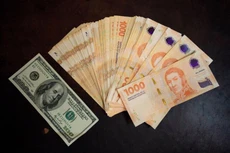Số tờ tiền 1.000 peso Argentina có trị giá tương đương tờ 100 USD vào thời điểm tháng 1 năm nay - Ảnh: Bloomberg.