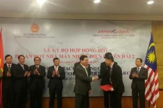 Bộ trưởng Bộ Công Thương Vũ Huy Hoàng trao cam kết bảo lãnh của Chính phủ Việt Nam cho đại diện Công ty Janakuasa. Ảnh: Đức Dũng/BNEWS/TTXVN