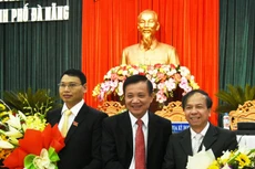 Chủ tịch HĐND TP. Đà Nẵng Trần Thọ tặng hoa cho ông Hồ Kỳ Minh, tân Phó Chủ tịch UBND TP Đà Nẵng (bên trái) và ông Võ Duy Khương (bên phải). Ảnh: VGP/Minh Trang. 
