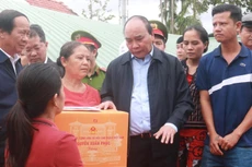 Chủ tịch nước Nguyễn Xuân Phúc thăm và tặng quà động viên người dân vùng ngập lụt sớm vượt qua khó khăn, ổn định cuộc sống.