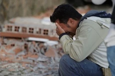 Một người đàn ông ôm mặt khóc bên đống đổ nát tại thị trấn Amatrice. Ảnh:Reuters