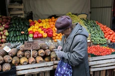 Một người dân đứng trước quầy hàng thực phẩm ở Saint Petersburg - Ảnh: Bloomberg