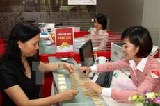 Khách giao dịch mua vàng tại Hội sở Techcombank tại Hà Nội. (Ảnh: Trần Việt/TTXVN)