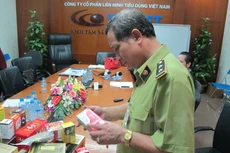 Cơ quan chức năng kiểm tra hoạt động Công ty Liên Minh Tiêu dùng Việt Nam năm 2014. (Ảnh: PV/Vietnam+)