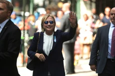 Hillary Clinton vẫy tay trước căn hộ của con gái, sau khi phải ra về sớm lễ tưởng niệm vụ 11/9. Ảnh: AP