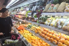 Một khách hàng đang xem hoa quả nhập khẩu tại siêu thị ở Thượng Hải. Ảnh:Nikkei