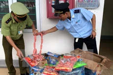Lực lượng liên ngành thành phố Móng Cái bắt giữ lô hàng thực phẩm nhập lậu không rõ nguồn gốc. (Ảnh: Văn Đức/TTXVN)