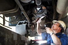 Nhân viên đăng kiểm tiến hành kiểm định phương tiện. (Ảnh: Hoàng Hùng/TTXVN)