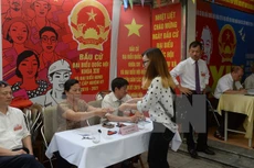 Cử tri Việt Nam nhận phiếu bầu tại một điểm bầu cử ở thủ đô Hà Nội ngày 22/5. (Ảnh: AFP/TTXVN)