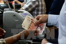 Kiểm đồng bảng Anh tại một điểm giao dịch ngoại hối ở Singapore ngày 24/6. (Nguồn: AFP/TTXVN)