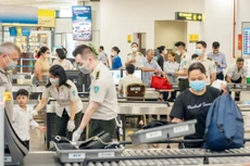Nhân viên an ninh tại Cảng hàng không quốc tế Nội Bài kiểm tra hành khách qua cửa soi chiếu