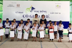Đại diện Tập đoàn Novaland và lãnh đạo địa phương trao học bổng đến các em học sinh hiếu học 