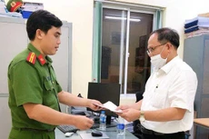 Công an tống đạt các quyết định khởi tố bị can, bắt tạm giam ông Tất Thành Cang. Ảnh: Công an cung cấp.