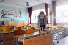Vệ sinh bàn ghế, lớp học chuẩn bị cho học sinh quay trở lại trường. Nguồn: TTXVN