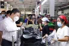 Phó Chủ tịch UBND Thành phố Hồ Chí Minh Dương Anh Đức thăm hỏi công nhân tại các chuyền sản xuất của Công ty Trách nhiệm hữu hạn Pouyuen Việt Nam ở quận Bình Tân. Ảnh: TTXVN