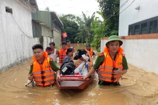  Công an tỉnh Nghệ An dùng thuyền hỗ trợ các cụ già, người ốm đau, bệnh tật đến nơi an toàn