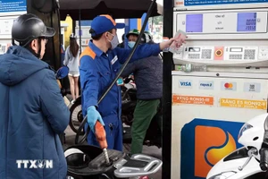 Khách hàng mua bán xăng, dầu tại một điểm kinh doanh xăng dầu của Petrolimex trên địa bàn Hà Nội. (Ảnh: Trần Việt/TTXVN)