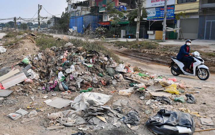 Mặt đường khu vực này chưa được thi công. Nhiều hố công trình sâu, khói bụi và những bãi rác xuất hiện ngay giữa đường.