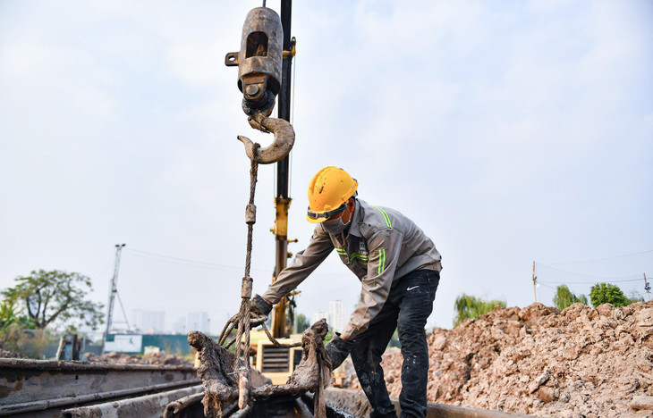 Hiện nay, 3 - 4 công nhân thi công cầm chừng tại đoạn đầu tuyến. &quot;Chúng tôi mới thi công trở lại khoảng 3 tháng nay, công việc là đóng cọc làm tường vây để xây dựng cống thoát nước ở đoạn đầu tuyến khu vực Đầm Hồng&quot;, anh Phan Văn Huấn nói.