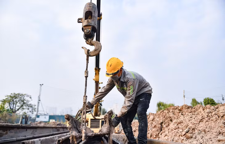 Hiện nay, 3 - 4 công nhân thi công cầm chừng tại đoạn đầu tuyến. "Chúng tôi mới thi công trở lại khoảng 3 tháng nay, công việc là đóng cọc làm tường vây để xây dựng cống thoát nước ở đoạn đầu tuyến khu vực Đầm Hồng", anh Phan Văn Huấn nói.