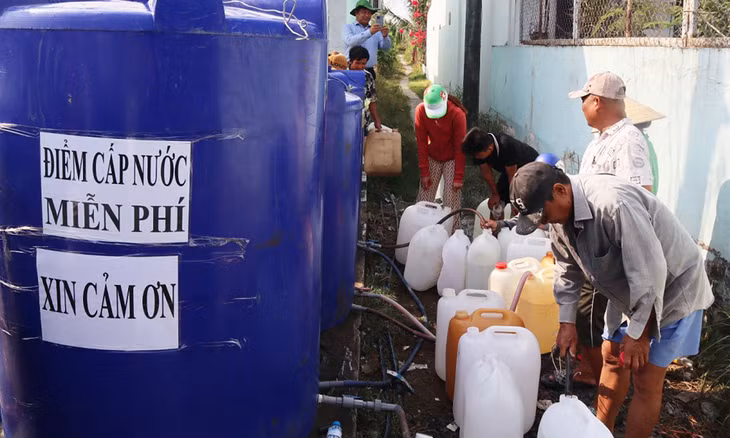 Người dân tại xã Tân Tập, Cần Giuộc mang can xin nước tại các điểm cấp miễn phí