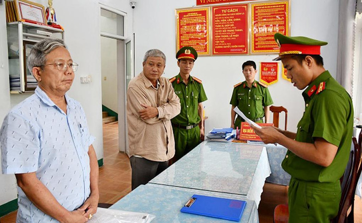 Cảnh sát đọc lệnh khởi tố và lệnh bắt ông Thái Minh Hoàng (bên trái) và Nguyễn Đình Tấn (ở giữa)