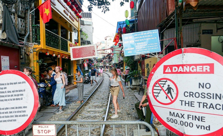 Bất chấp biển cảnh báo, khách nước ngoài vẫn tới phố đường tàu để trải nghiệm