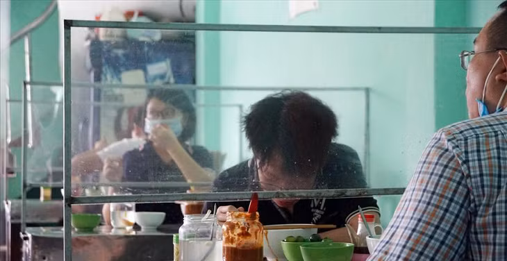 Các khách hàng trong nhà được bố trí giữ khoảng cách, các bàn đều được trang bị màn chắn đảm bảo an toàn cho mọi người.