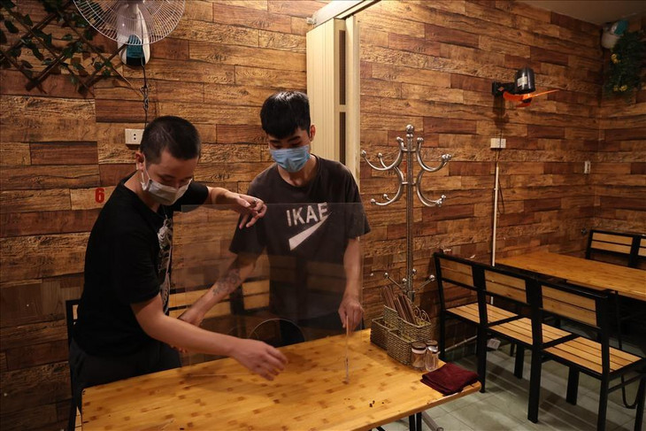 Theo yêu cầu của UBND TP.Hà Nội, các chủ cửa hàng dịch vụ ăn uống trong nhà đảm bảo khoảng cách, có tấm chắn giữa người với người, ngồi không quá 50% công suất chỗ ngồi và không quá 20 người, đóng cửa trước 21h00 hàng ngày (nhà hàng rượu, quán rượu, bia, bia hơi chỉ được phép bán hàng mang về).