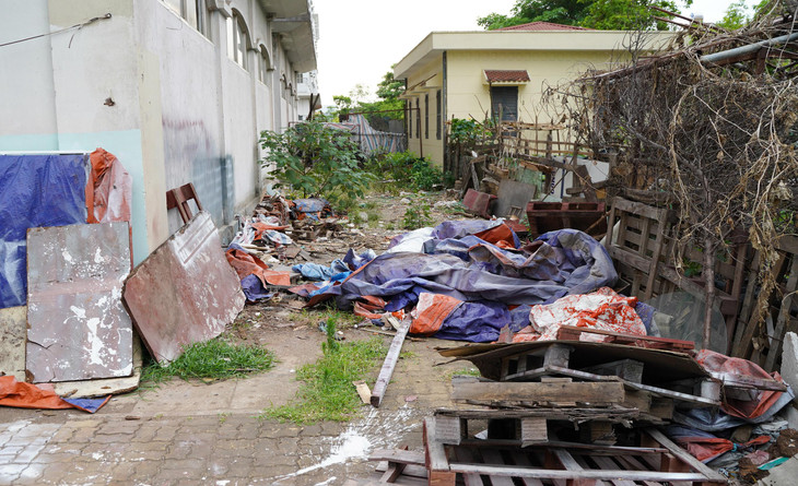 Khung cảnh nhếch nhác, rác thải xây dựng tràn ngập, cây cỏ mọc um tùm phía sau các tòa nhà này. Khung cảnh nhếch nhác, rác thải xây dựng tràn ngập, cây cỏ mọc um tùm phía sau các tòa nhà này.