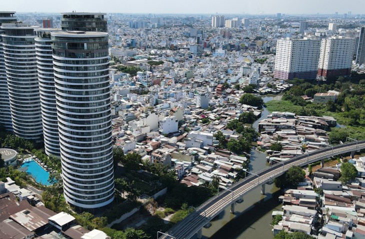 Dãy nhà lụp xụp ven rạch Văn Thánh, quận Bình Thạnh, kế bên là các cao ốc và đoạn trên cao Metro Bến Thành - Suối Tiên chạy qua