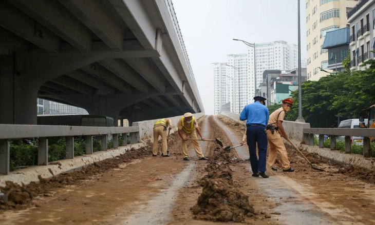 Lực lượng chức năng dọn dẹp bùn đất rơi vãi