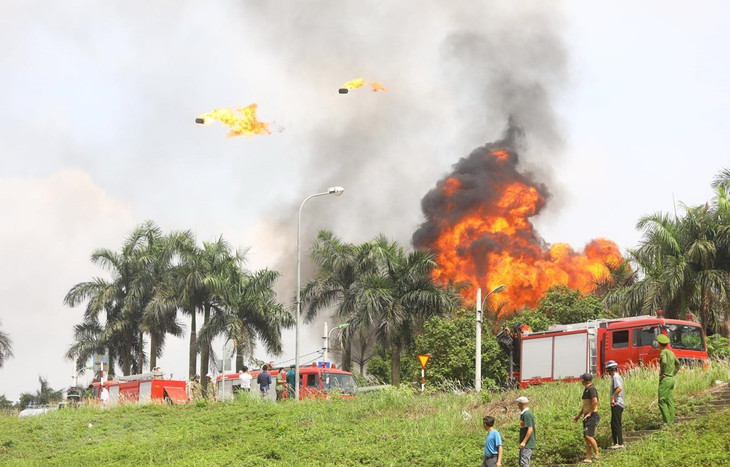 Một số thùng phuy chứa hóa chất phát nổ, bay lên cao hàng chục mét. Ảnh: TTXVN