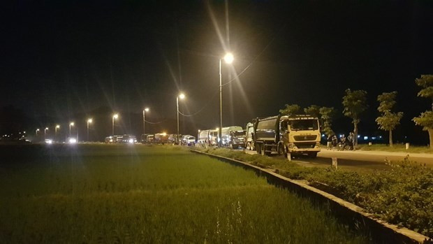 Xe chở rác nằm chờ bên ngoài khu vực bãi rác.