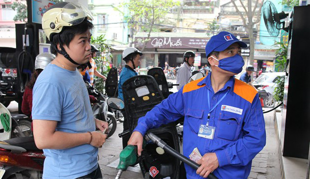 Nhân viên Petrolimex đang bán xăng cho khách hàng Nhân viên Petrolimex đang bán xăng cho khách hàng