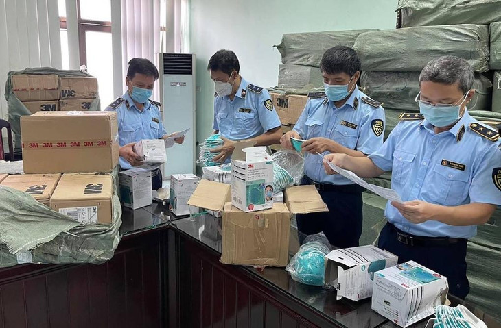 Cán bộ đội quản lý thị trường số 1 kiểm tra lô khẩu trang 3M có dấu hiệu bị làm giả