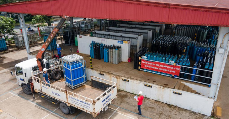 Những bình khí được cẩu lên xe tải để giao đến các cơ sở y tế