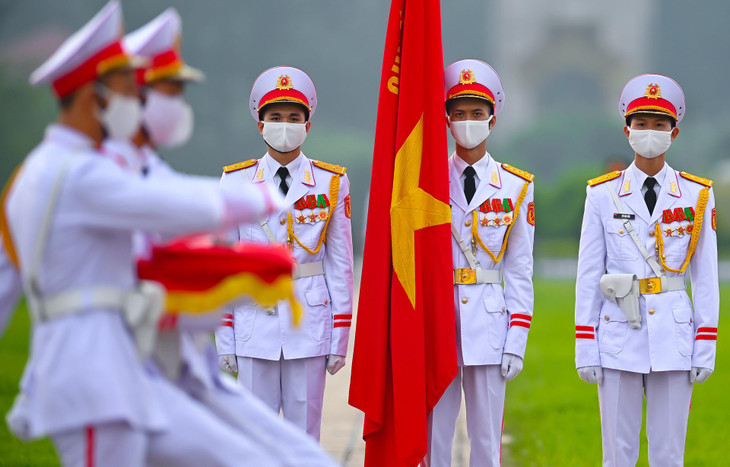 Đoàn đi một vòng ra phía trước theo tiếng nhạc của ca khúc Tiến bước dưới quân kỳ để đến chân cột cờ