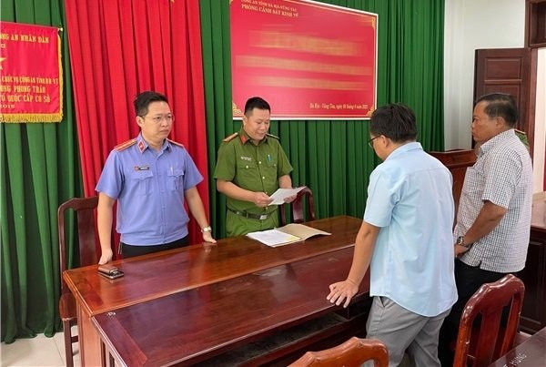 Hai trong số 13 bị can vừa bị khởi tố nghe cơ quan điều tra tống đạt các quyết định