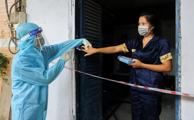 Nhân viên y tế Phường 3, Quận 8, đến thăm khám, tặng thuốc cho người mắc Covid-19 đang điều trị tại nhà